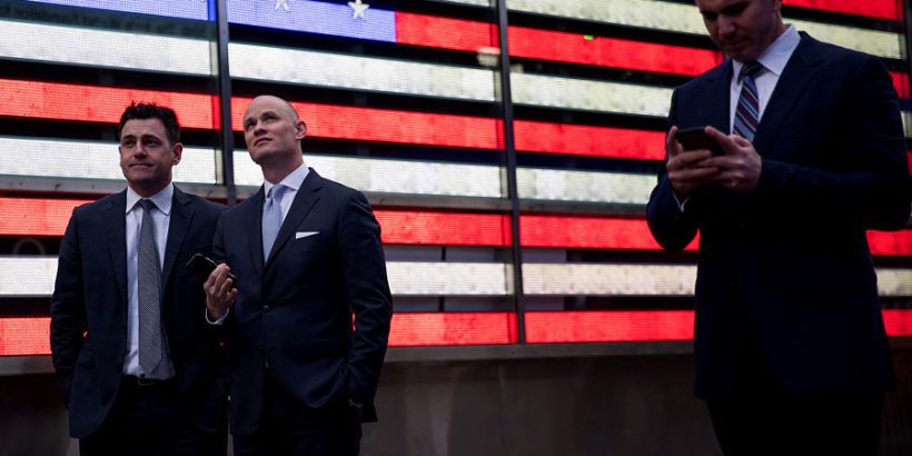 traders in front of image of American flag