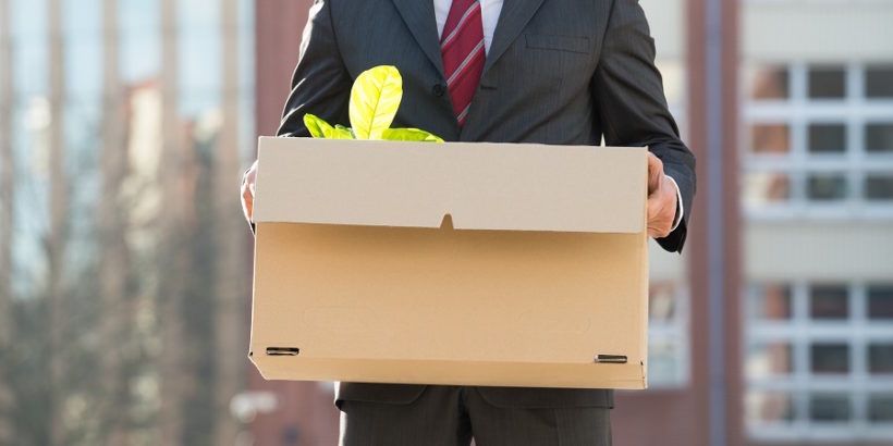 businessperson-walking-out-of-building-with-box